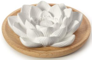 Duftstein in Lotusblüte auf einem runden Holzuntersetzer. Stressabbau durch Aromatherapie.
